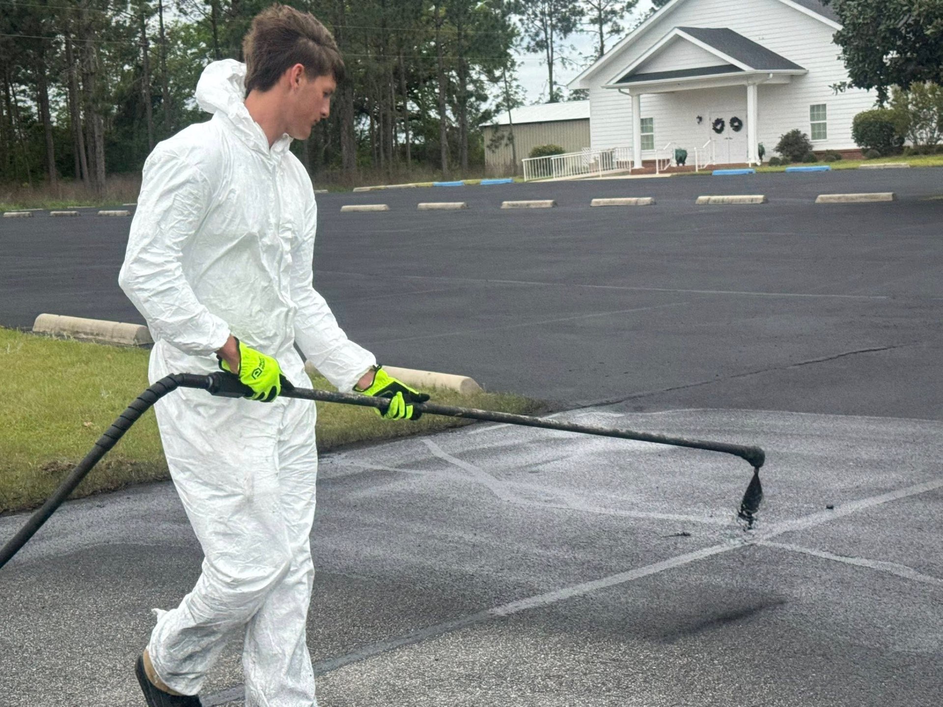 Crack repair and seal coating in progress on asphalt