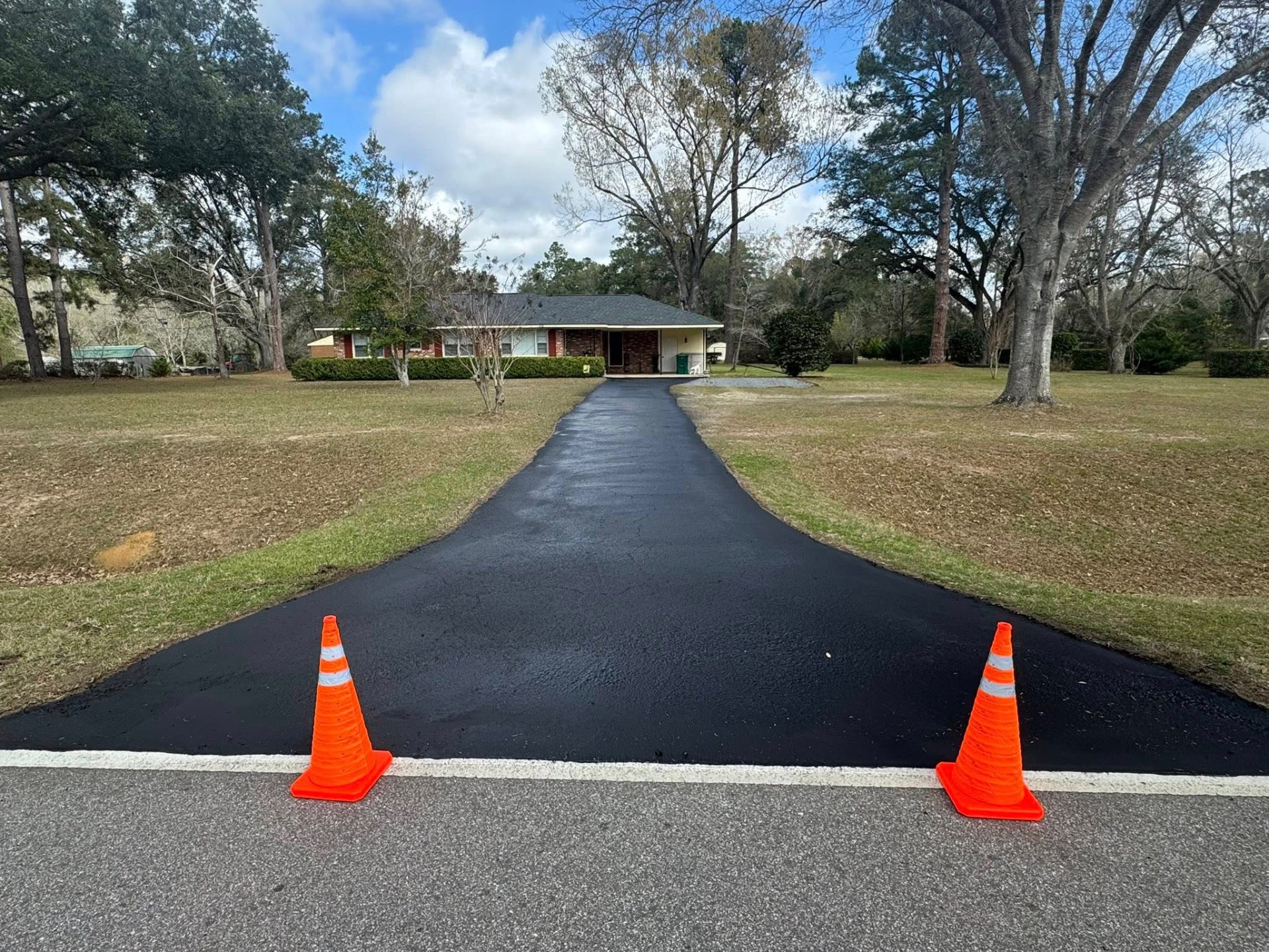 Freshly seal-coated residential driveway with safety cones